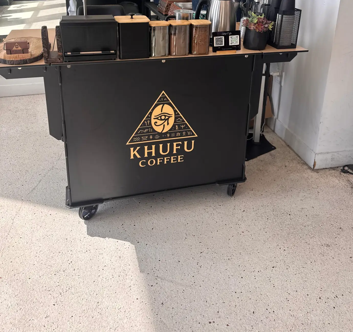The Khufu Coffee cart set up indoors, kettle and canisters along the counter